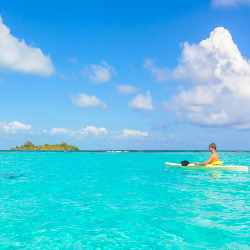 Canoe floating on transparent turquoise water, caribbean sea, Belize, Cayes islands copy