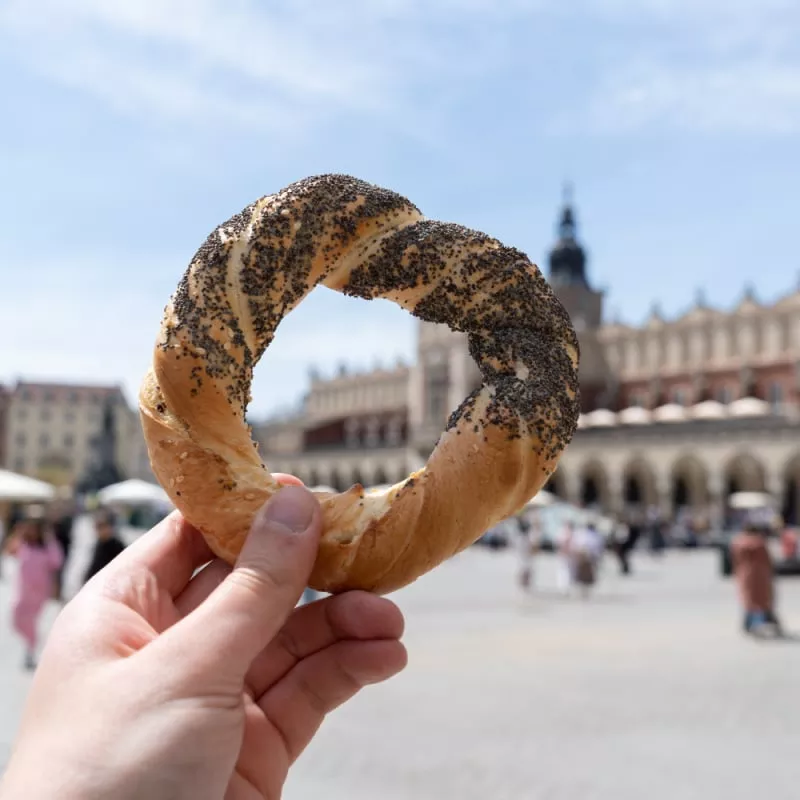 Hand holding obwarzanek krakowski prezel on Krakow