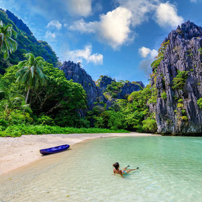 A Woman Relaxing As She Swims On The Ocean In Palwan, Philippines, Southeast Asia