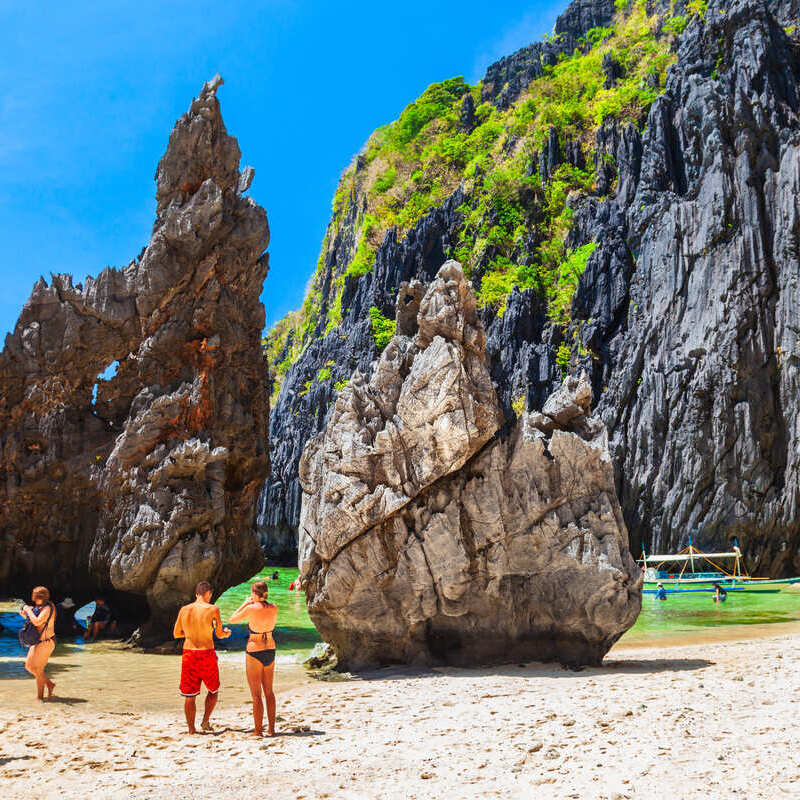 Tourists On A Beach In Palawan, Southeast Asia