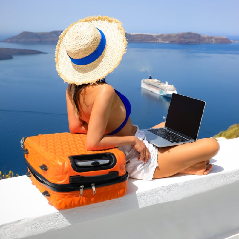 Digital nomad woman with suitcase and laptop in greece europe sea