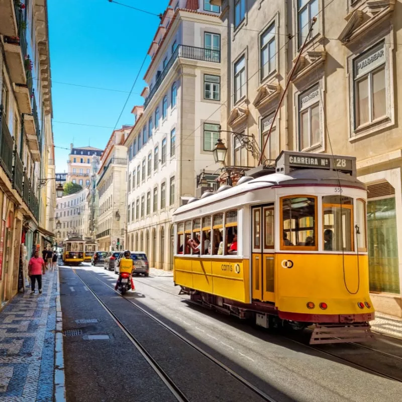 People walking by the tram line in the cener of the city in Lisbon