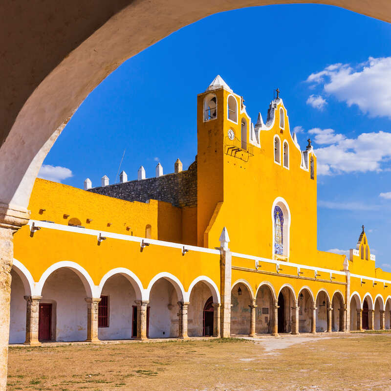 Yellow-Colored Convento de Santo Antonio de Padua In Izamal Seen Through The Arched Terraces, Izamal, Mexico