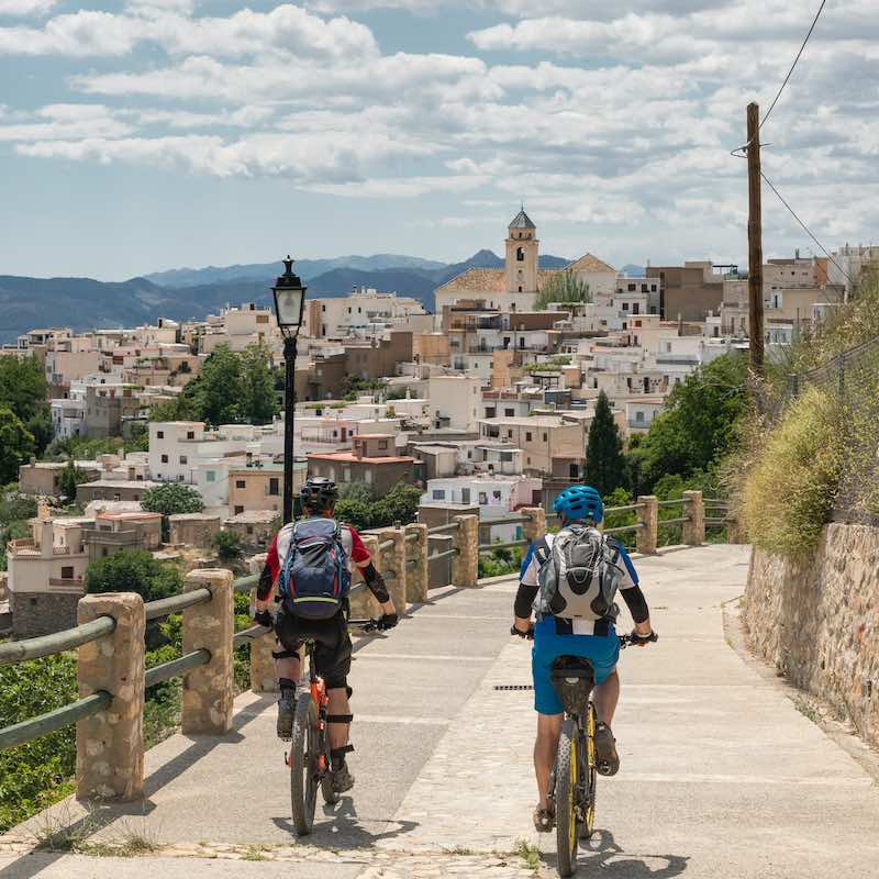 Two female mountainbikers are approaching the village of Canar in the Andalucian Sierra Nevada which is a mountain range in the province of Granada and, a little further, Málaga and Almería in Spain