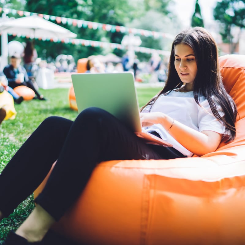 Female Digital Nomad Working From Her Laptop In A Cafe Or Coworking Spot, Unspecified Location