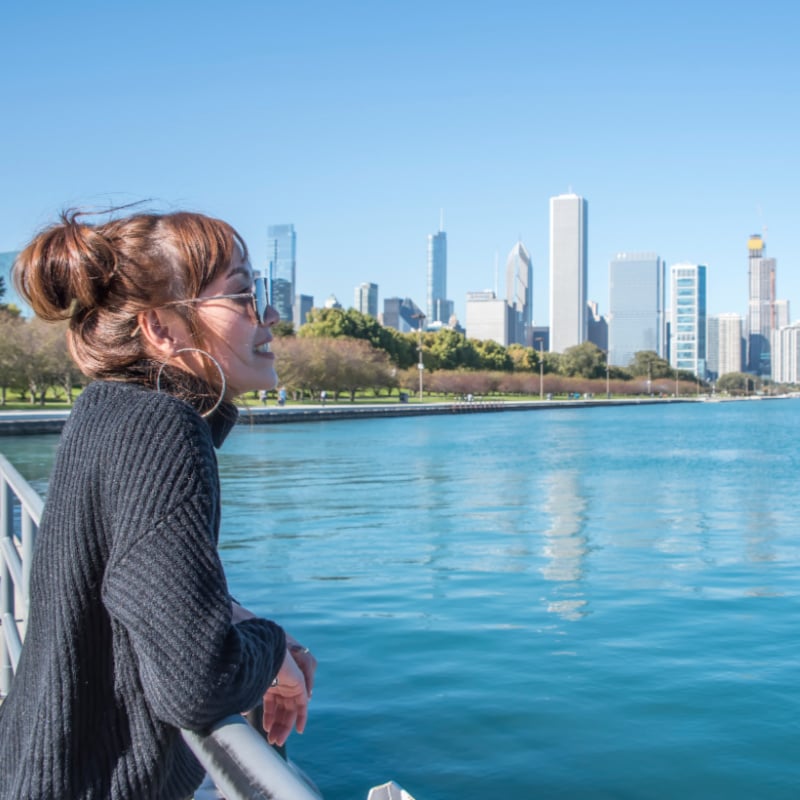 women standing in the City of Chicago downtown and she Walking around michigan lake at day time