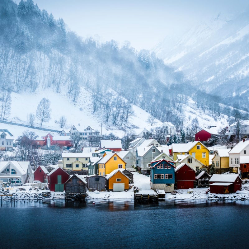 wooden houses on the banks of the Norwegian fjord, beautiful mountain landscape in winter