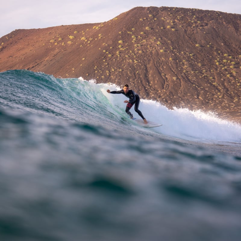 surfer riding waves on the island of fuerteventura