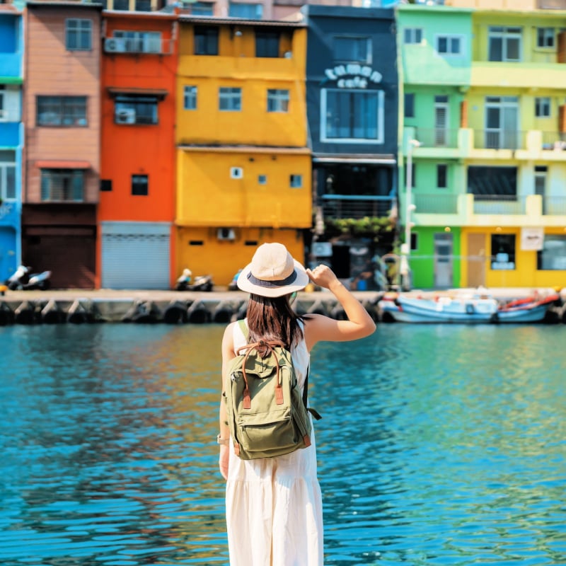 woman traveler visiting in Taiwan, Tourist with backpack and hat sightseeing in Keelung, Colorful Zhengbin Fishing Port, landmark and popular attractions near Taipei city . Asia Travel concept