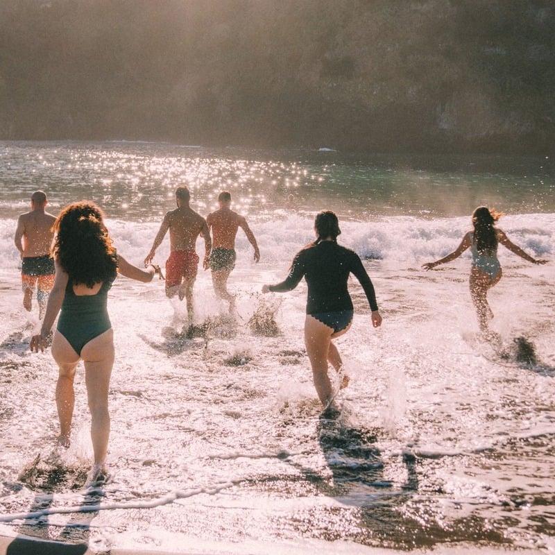 Tourists Running Into The Ocean In Seixal, A Volcanic Beach In Northern Madeira, Portugal, Southern Europe