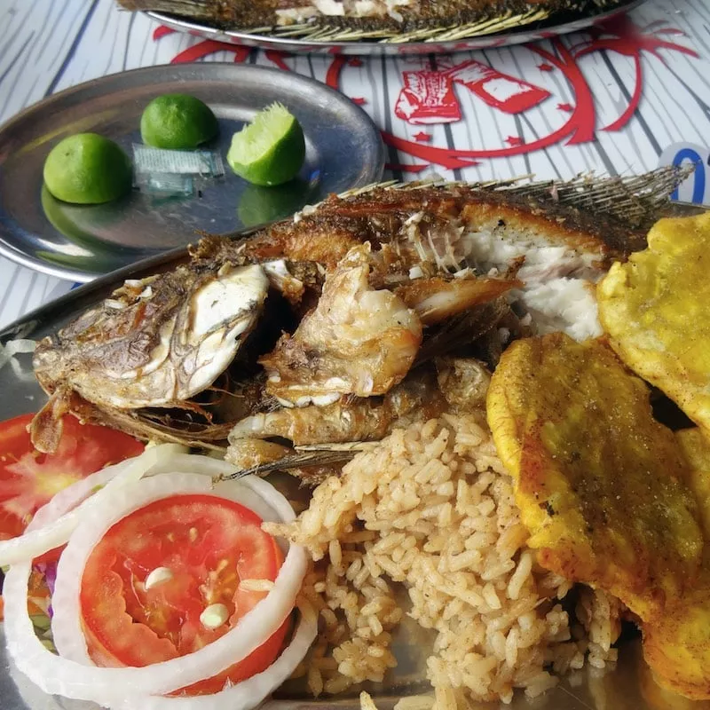 local food: plate of cooked fish with plantains, tomatoes and onions in Cartagena