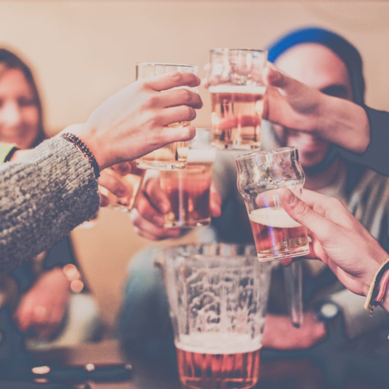 friends toasting over a beer in an apres ski lounge