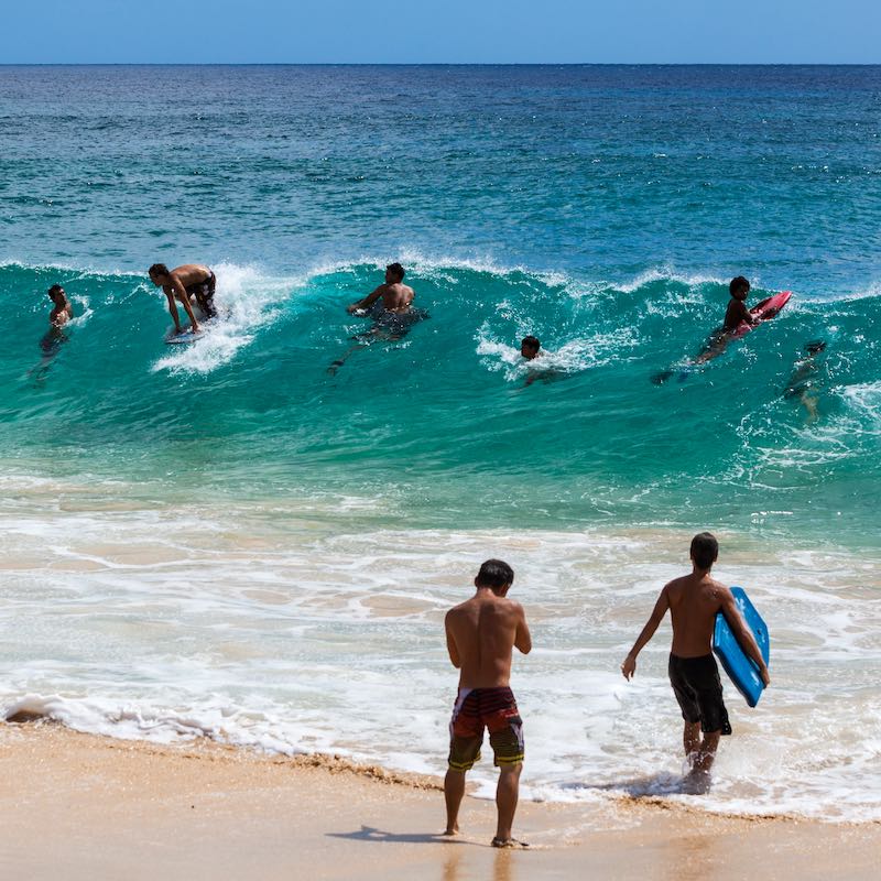 Surfers In Sandy Beach In Hawaii, United States