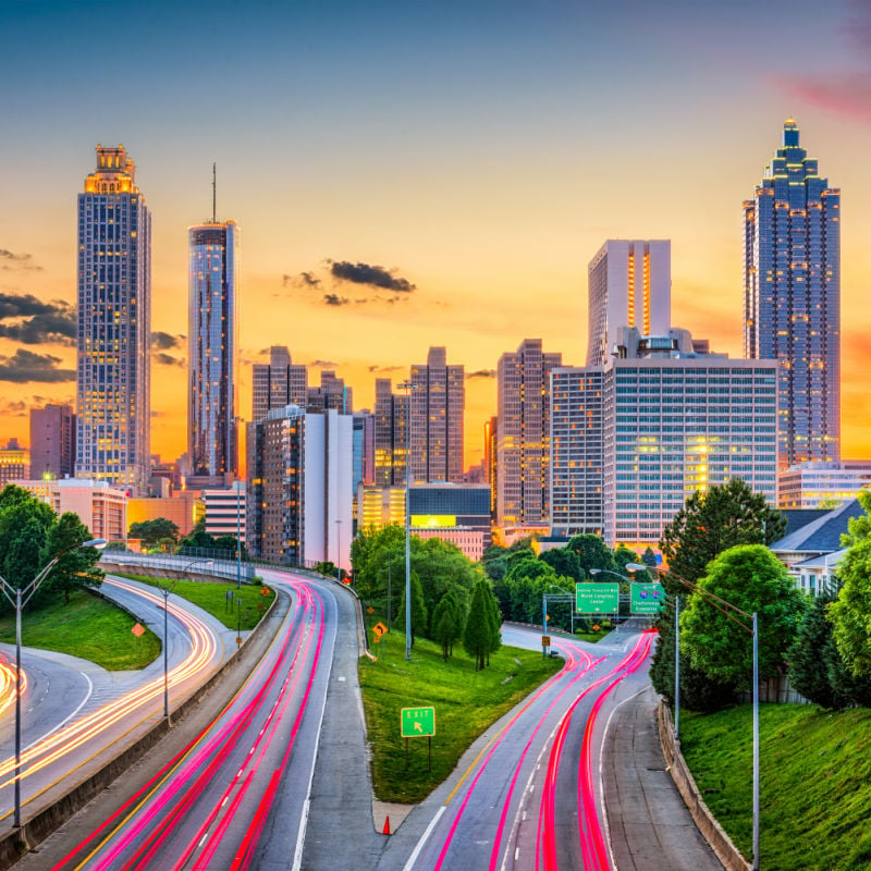 skyline of atlanta georgia at sunset with traffic passing