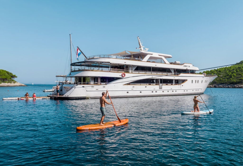 paddleboarding beside a yacht in Croatia