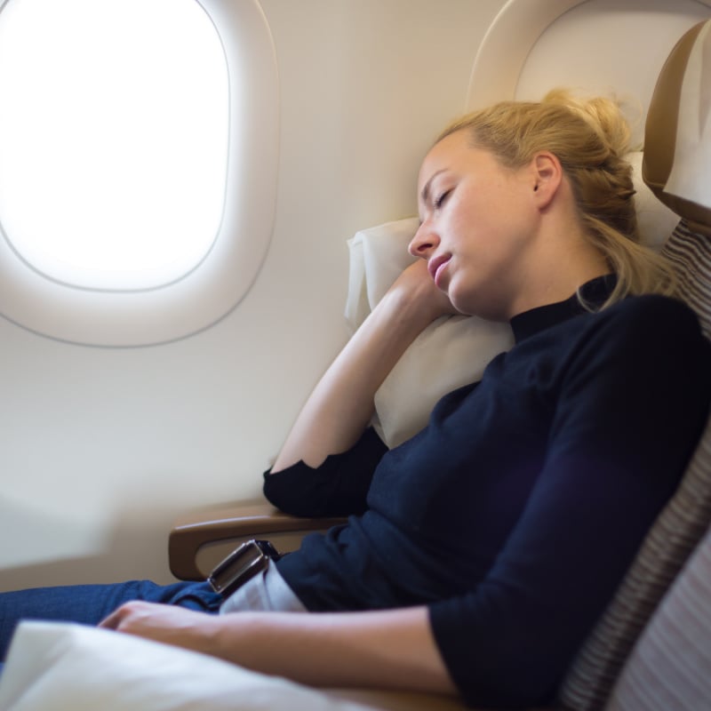 tired woman sleeping on a plane