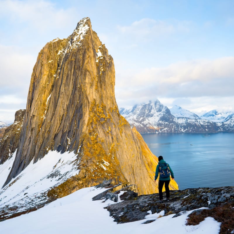 traveler with backpack hiking in Norway mountains