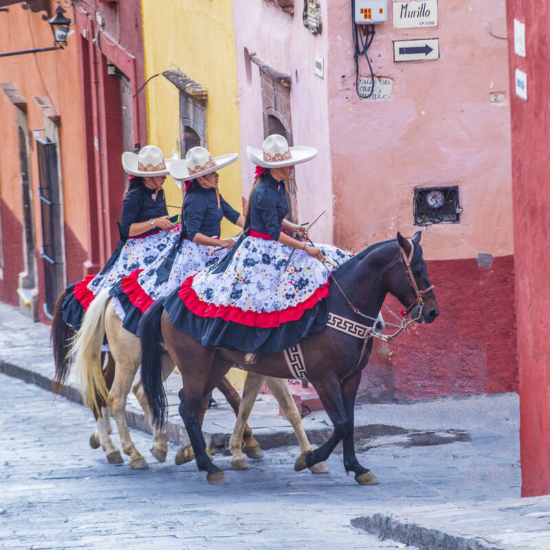 Mexican Women Riding Donkeys Through The Streets Of San Miguel de Allende, Mexico, Latin America