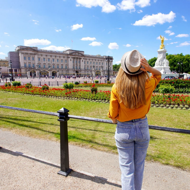 young traveler looks at buckingham palace in london on a sunny day