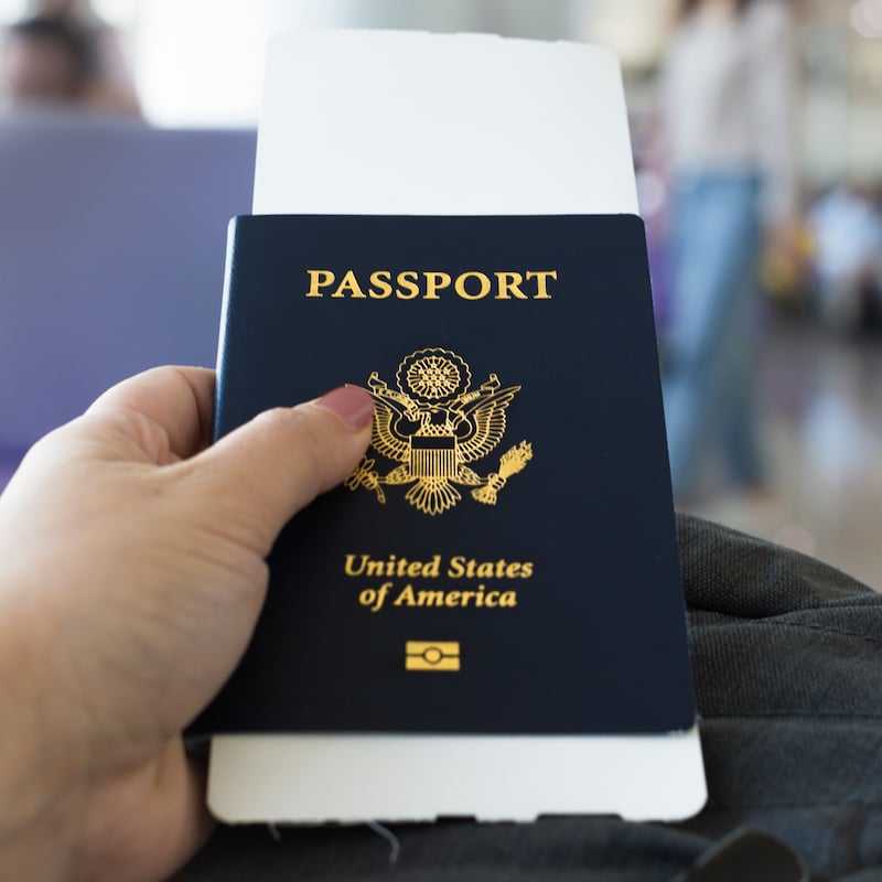 A woman holding her passport and ticket, waiting to board an airplane