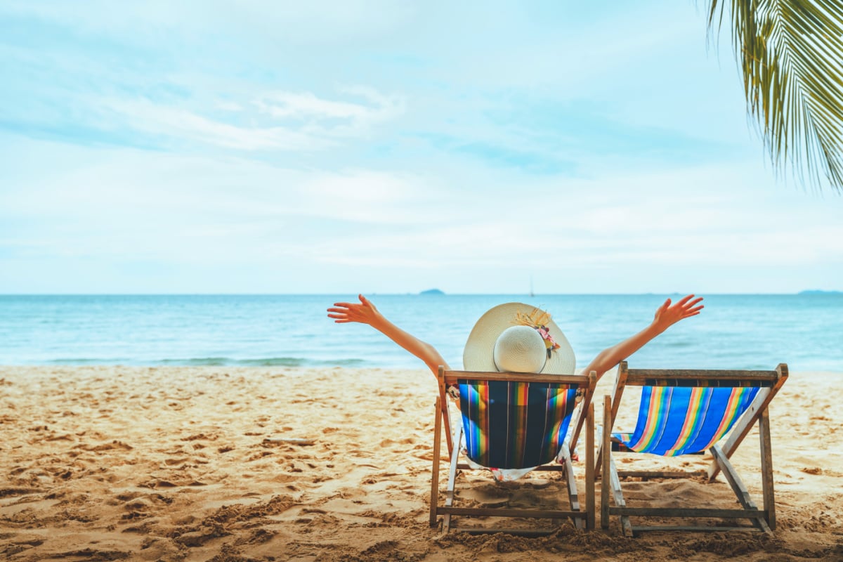 Happy traveler relaxing on a beach chair 