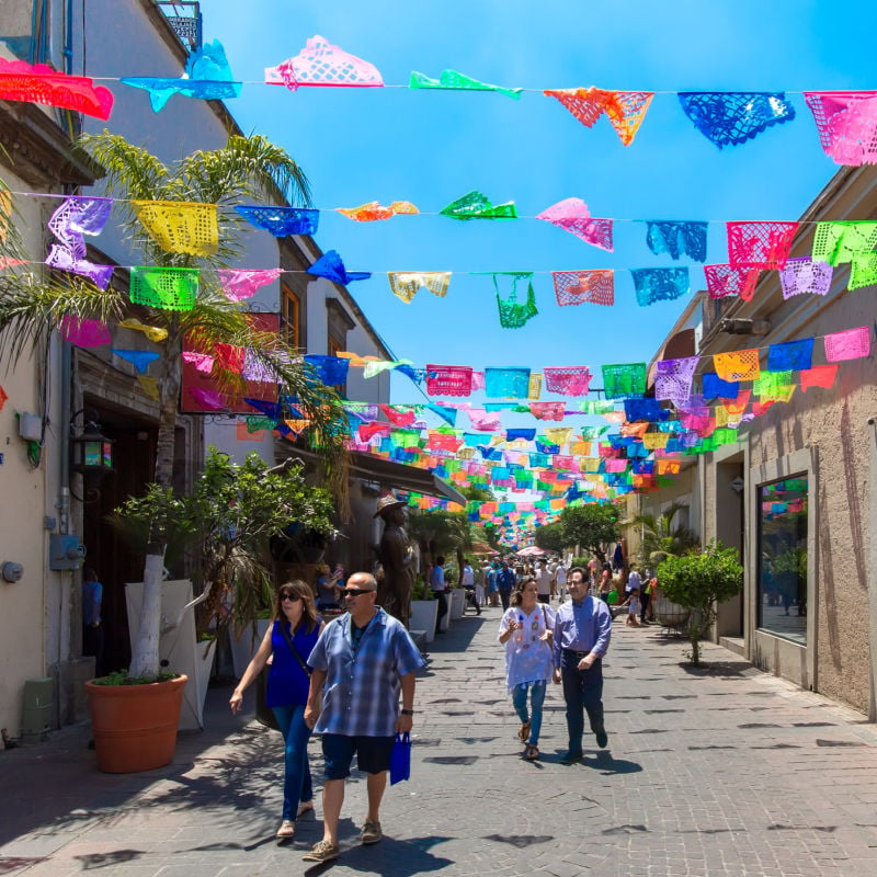 Tourists walking down vibrant street of Tlaquepaque near Guadalajara