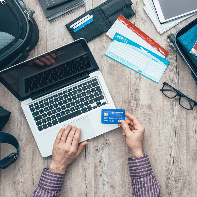 Traveler Booking A Flight On A Computer While Holding Up A Credit Card, Flight Booking Concept