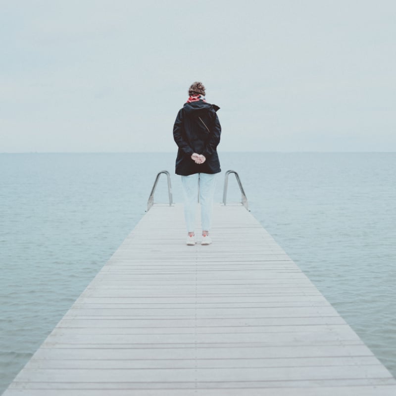 solo female traveler standing on pier at amager strand beach in copenhagen denmark