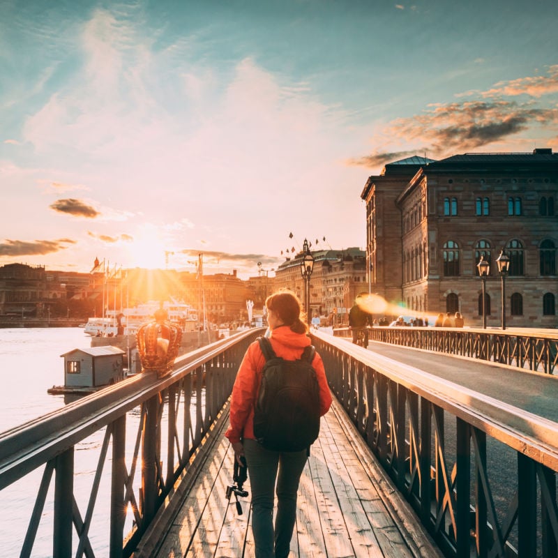 solo female traveler walking along a bridge in stockholm sweden