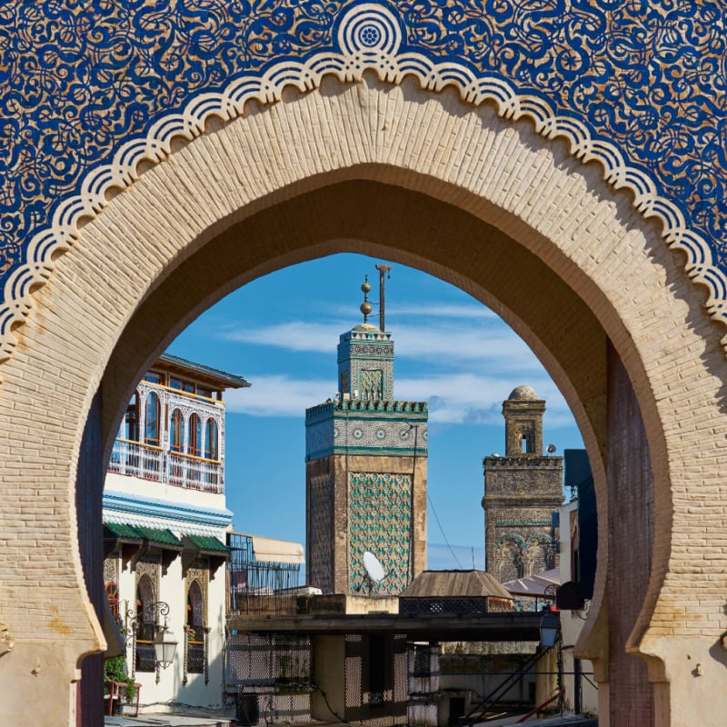 A view through a blue archway into the city of fes, morocco