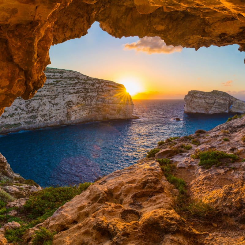 the sun sets behind rocks in scenic Gozo