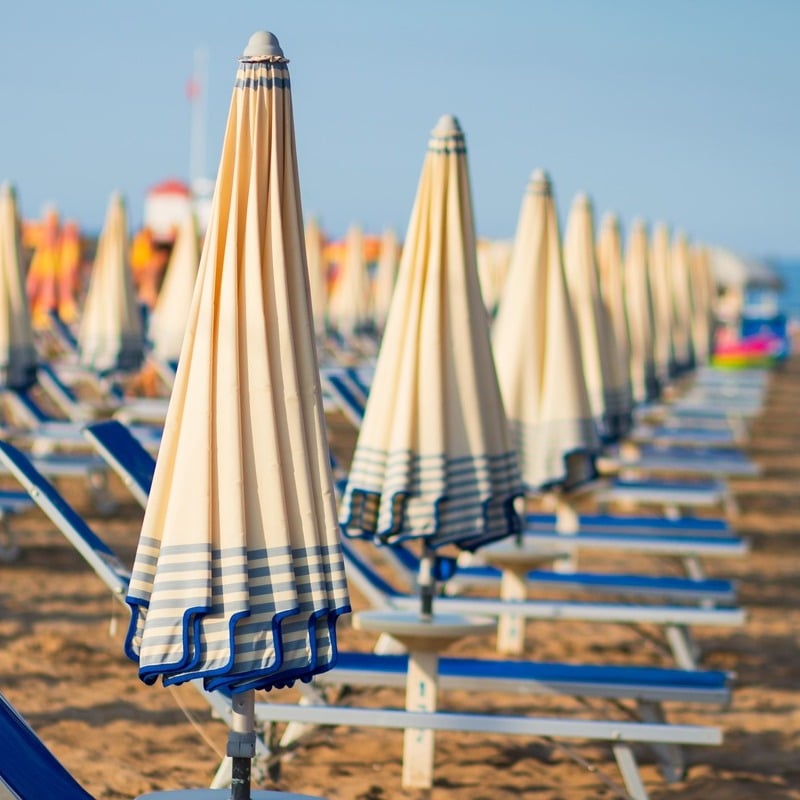 Row Of Beach Loungers With Closed Umbrellas In Rimini Beach, Italy, Southern Europe