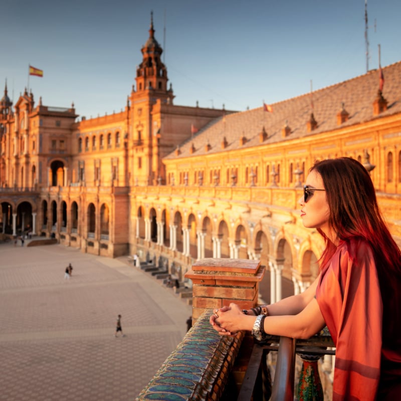 Woman looking out over balcony in Sevilla, Spain