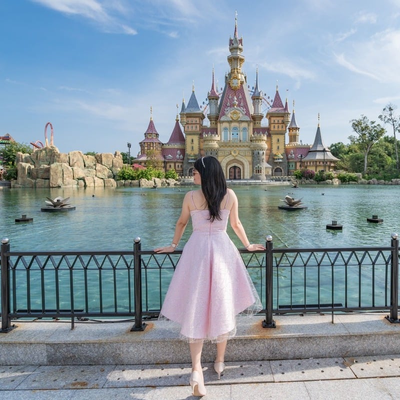 A Young Woman Posing For A Picture By The Fairytale Castle In VinWonder Phu Quoc, A Theme Park In Vietnam, Southeast Asia