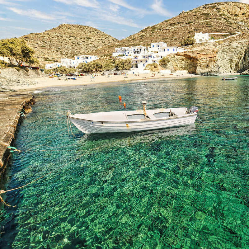 Boat Docked By A Crystal-Clear Harbor In Folegandros, An Island In The Mediterranean Sea, Greece, Southern Europe