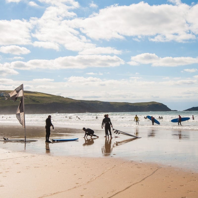 Surfers on Newquay beach, Cornwall, UK