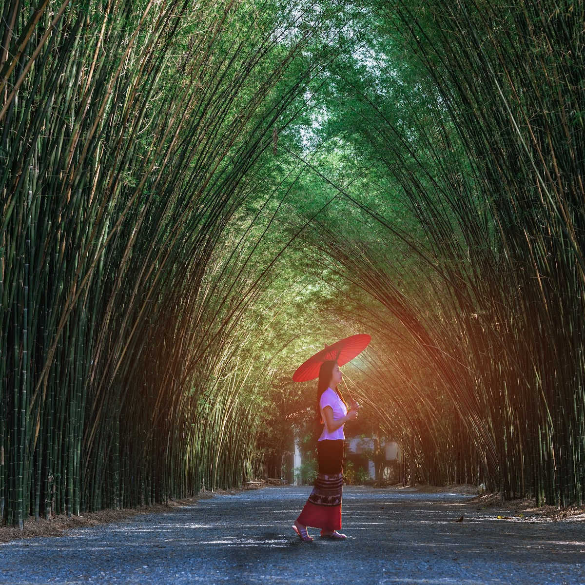 Woman inside green bamboo tunnel at temple entrance - Nakhon Nayok