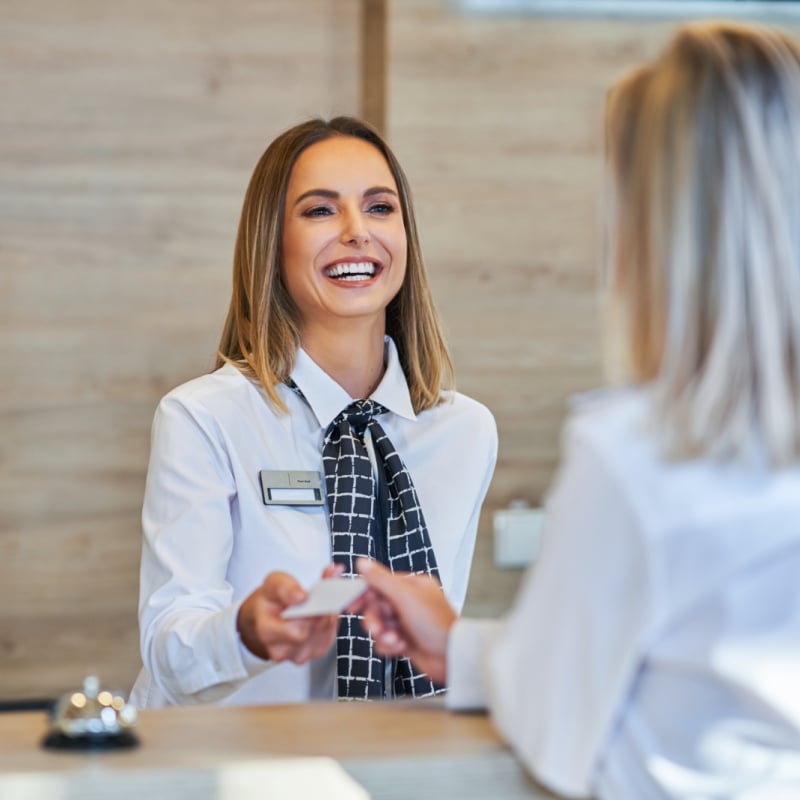 Woman paying for her hotel room at the front desk