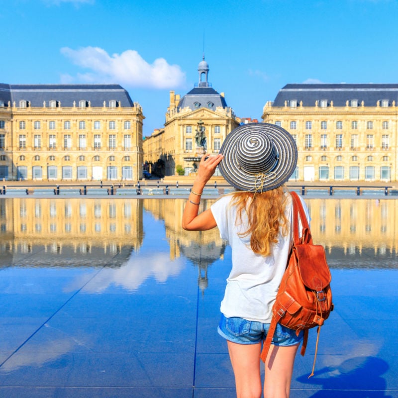 place de la bourse in bordeaux with a female traveler outside