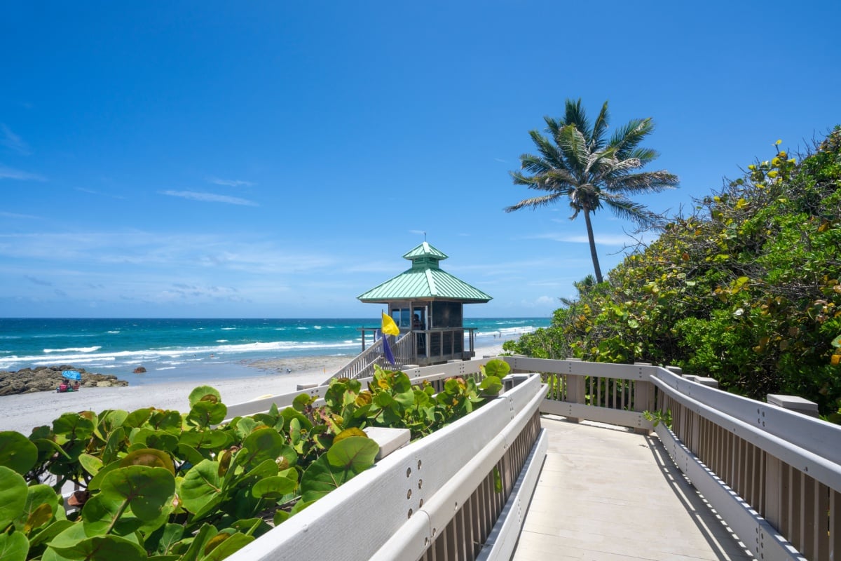 Boardwalk to beautiful Florida beach with crystal clear water and red rocks. Great place for snorkeling. Red Reef Park, Boca Raton, Florida USA