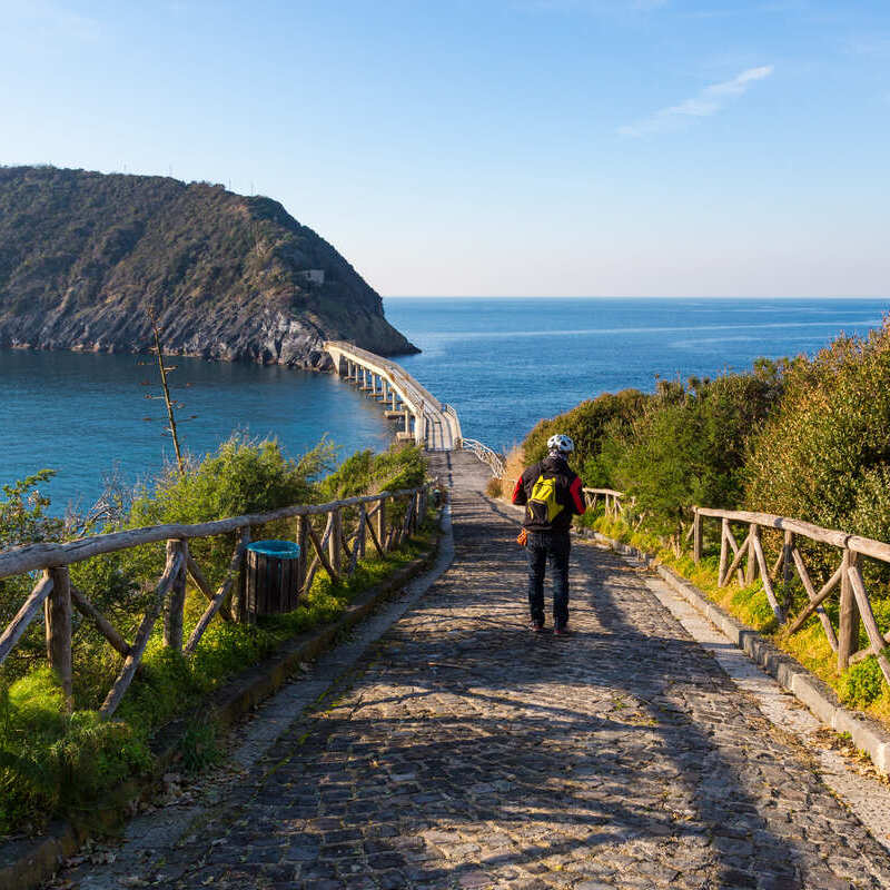 Tourist In Procida Crossing The Bridge To Vivara Islet, Italy, Southern Europe