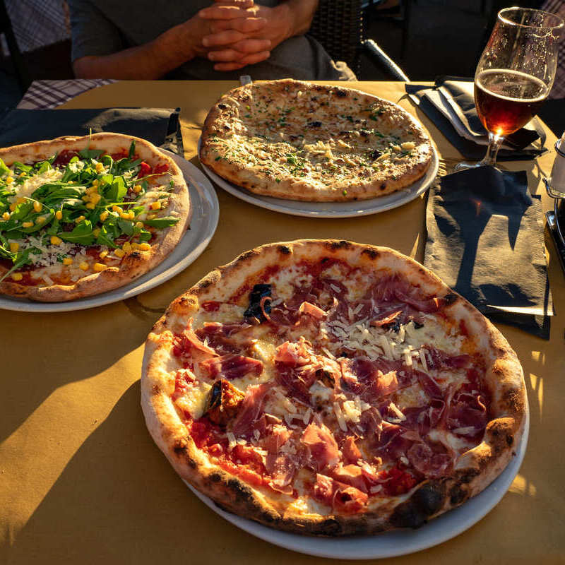 A Group Of Friends Eating Pizza In Trieste, Italy