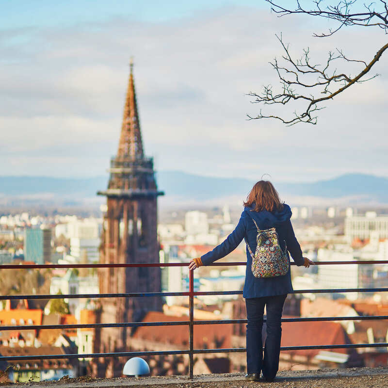 A Woman Admiring A View Of Freiburg Im Breisgau During Wintertime, Germany, Western Europe