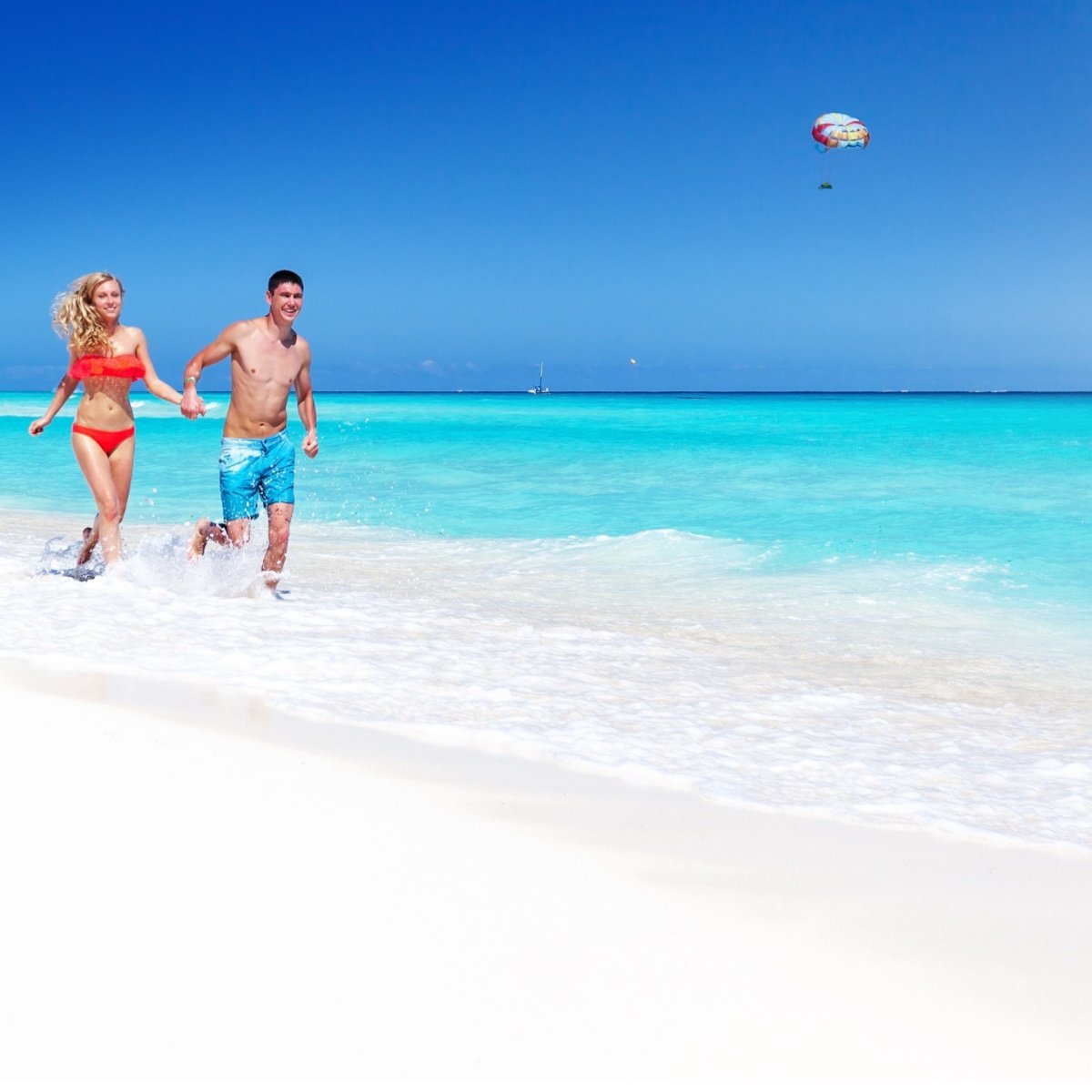 A couple running on the beach in Cancun