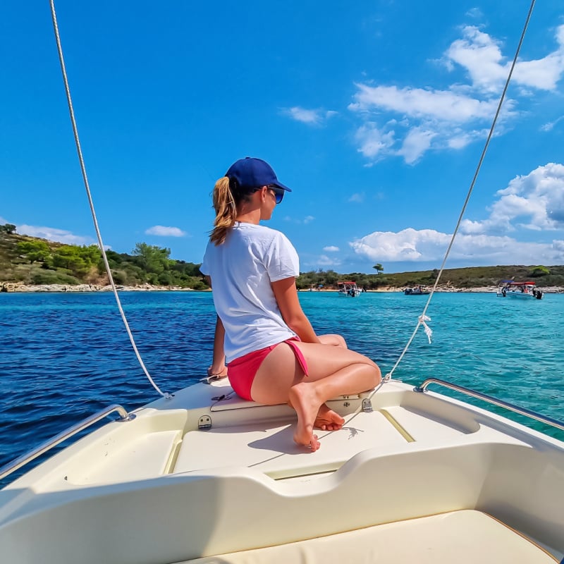 Woman on a boat in the blue lagoon of Vourvourou on peninsula Sithonia, Chalkidiki (Halkidiki), Greece