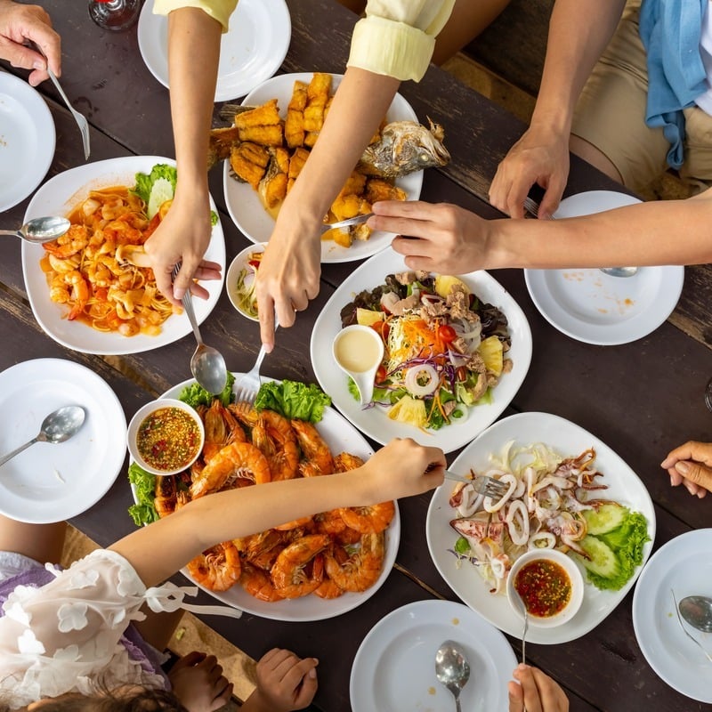 A Family Sharing A Seafood Platter In A Restaurant, Unspecified Location