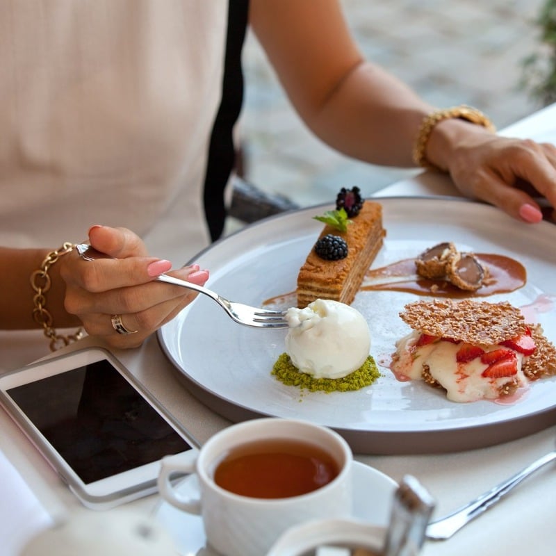 Young Woman Eating At An Alfresco Cafe In France