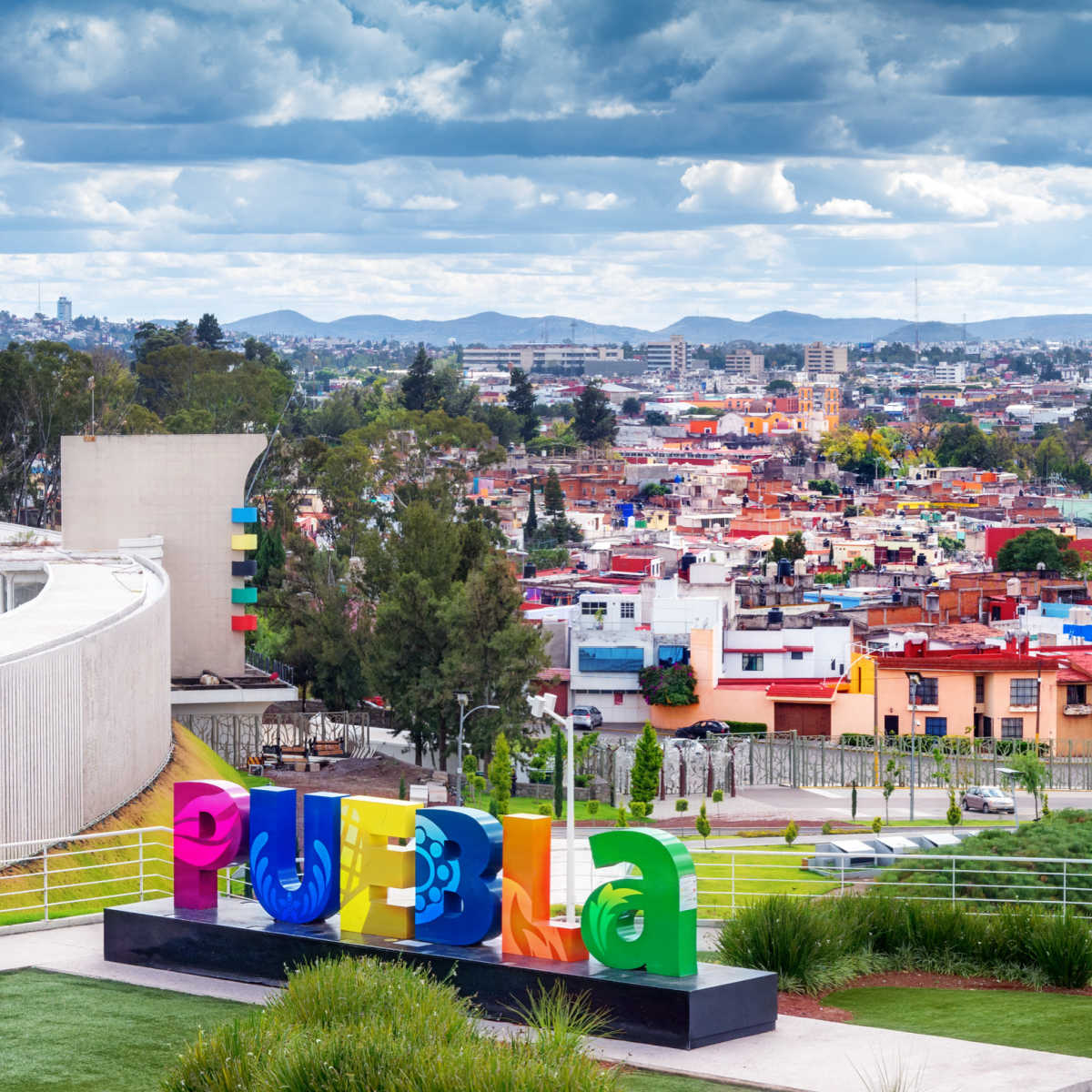 Colorful Puebla sign in front of vast cityscape