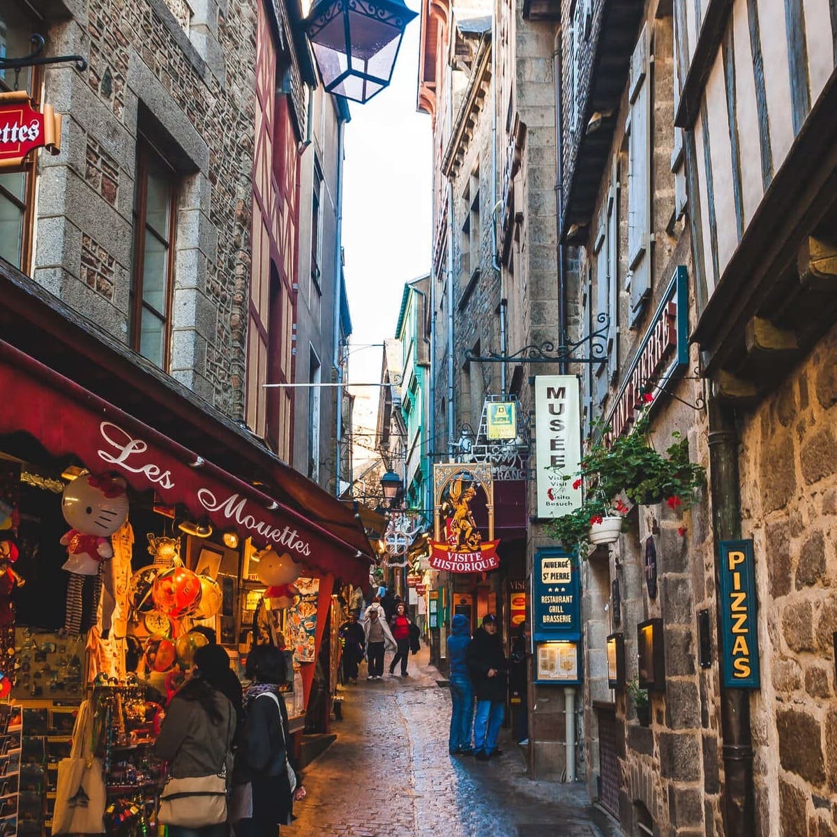 Narrow Street Lined With Shops And Restaurants In Mont Saint Michel, France