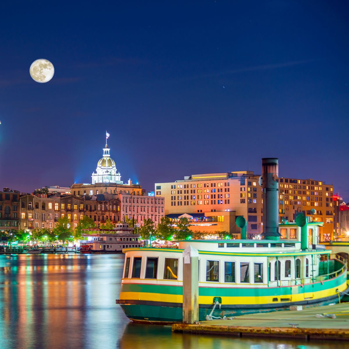 Riverboat in Savannah skyline under full moon